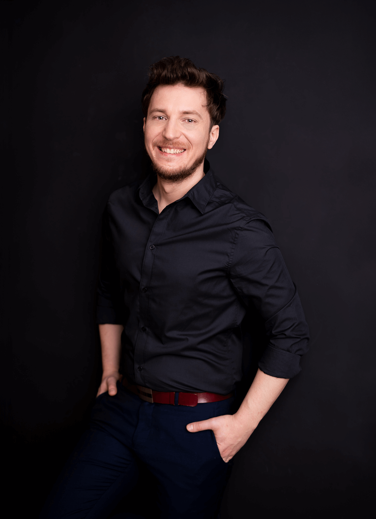 Dariusz Mierzejewski uśmiechnięty, w czarnej koszuli, ekspert od wideo i WordPressa, współzałożyciel Rise Up Team.